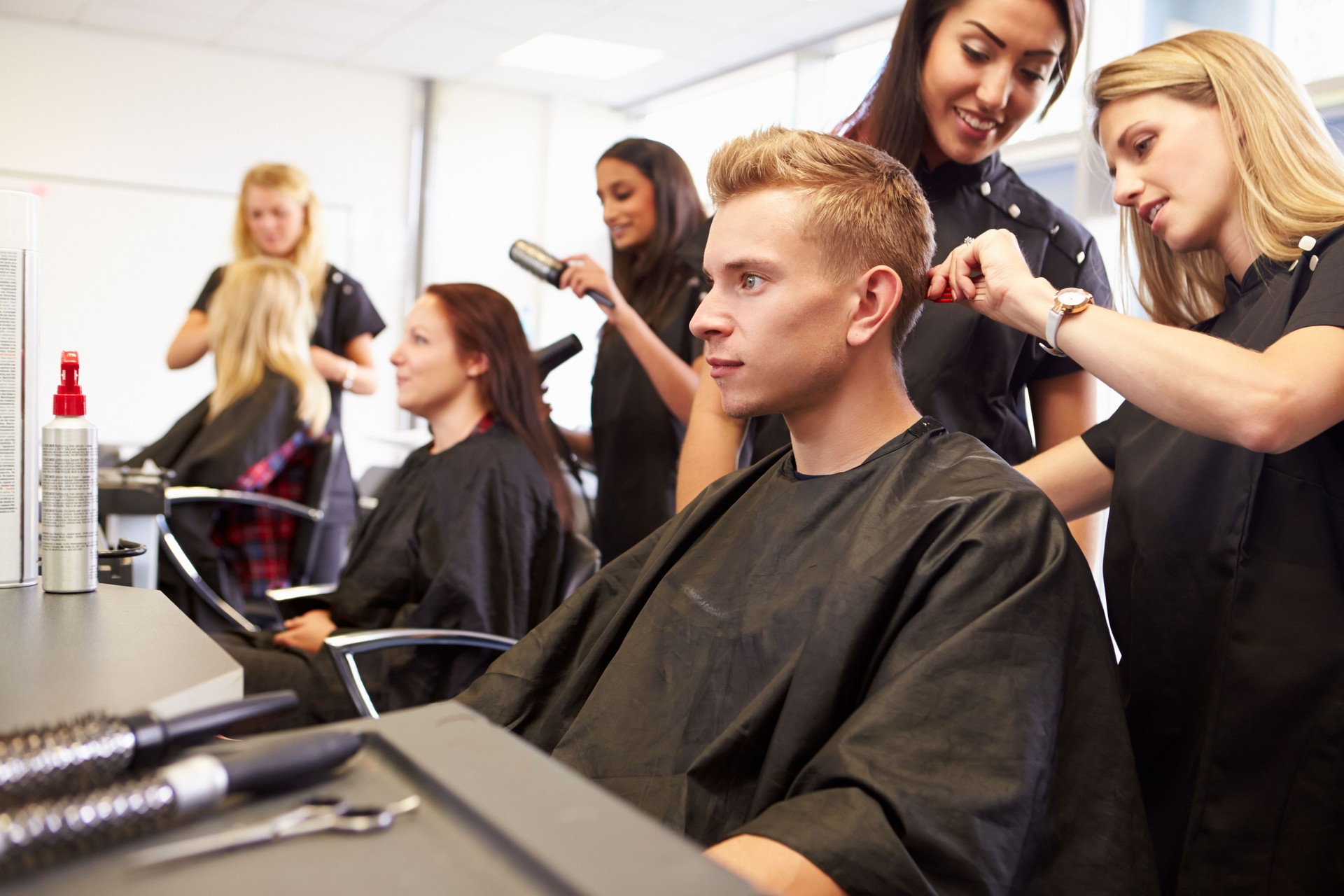 Teacher Helping Students Training To Become Hairdressers
